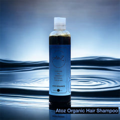 Bottle of Atoz Organic Hair Shampoo on a reflective water surface with a blurred background